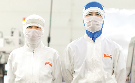 These photographs illustrate the four approaches to safety management in which the processed food business engages to deliver safe, high-quality products. These four approaches are: food safety, food defense, food quality, and food communication. The processed food business promotes safety management initiatives throughout the value chain, from product development to raw material procurement, manufacturing, and shipment.